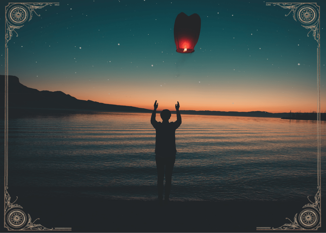 Mann lässt am See einen Ballon los